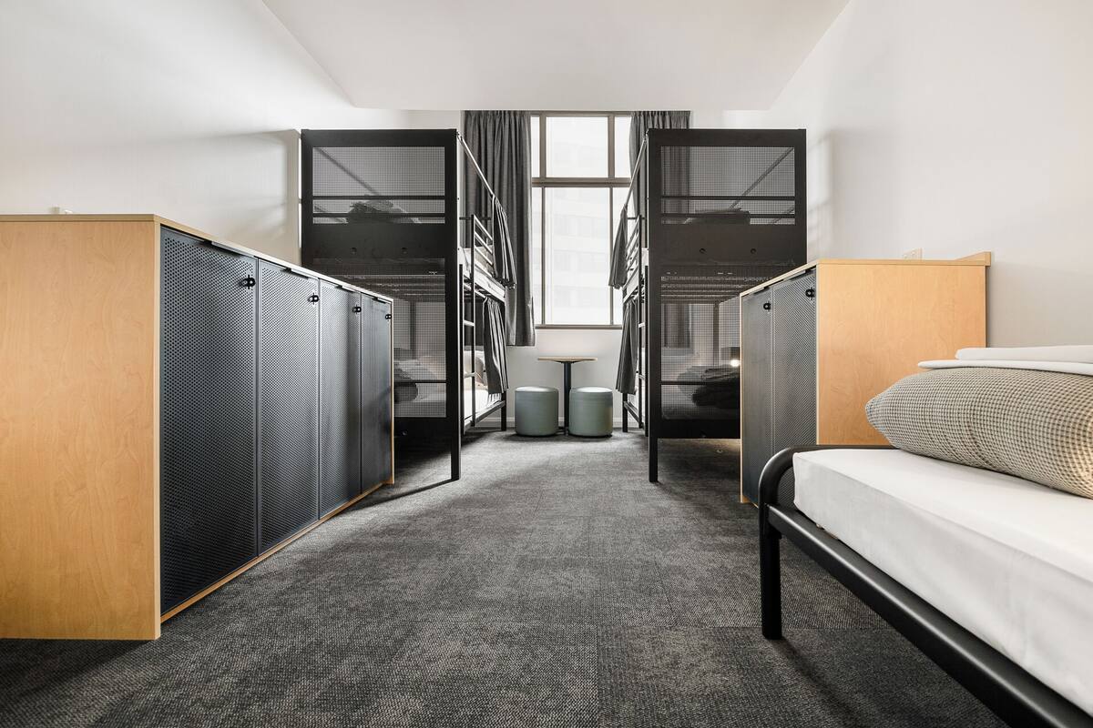 Una habitación de hotel con una cama, un escritorio y un armario.