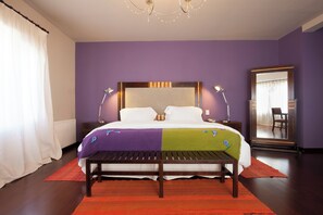 A bedroom with a bed, bedside lamps, a bench, and a large mirror. - Hotel Huacalera (Huacalera)
