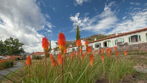 A building with a stone facade, green window frames, and a red-tiled roof. - Hotel Huacalera (Huacalera)