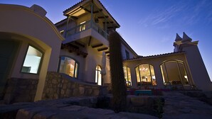 A multi-story house with a stone facade, a balcony, and large windows. - Hotel Huacalera (Huacalera)