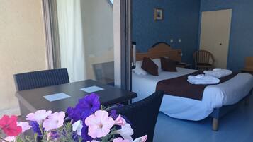 A hotel room with a bed, a bedside table, a chair, and a window.