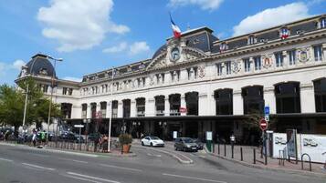A historic building with classical architecture, featuring multiple arches and a prominent clock tower.