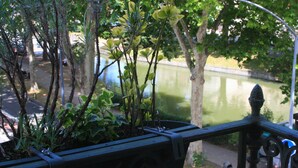 Een balkon met uitzicht op een rivier en bomen.