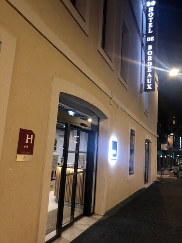 The exterior of Hotel De Bordeaux with a visible entrance and a sign indicating a room with a view.