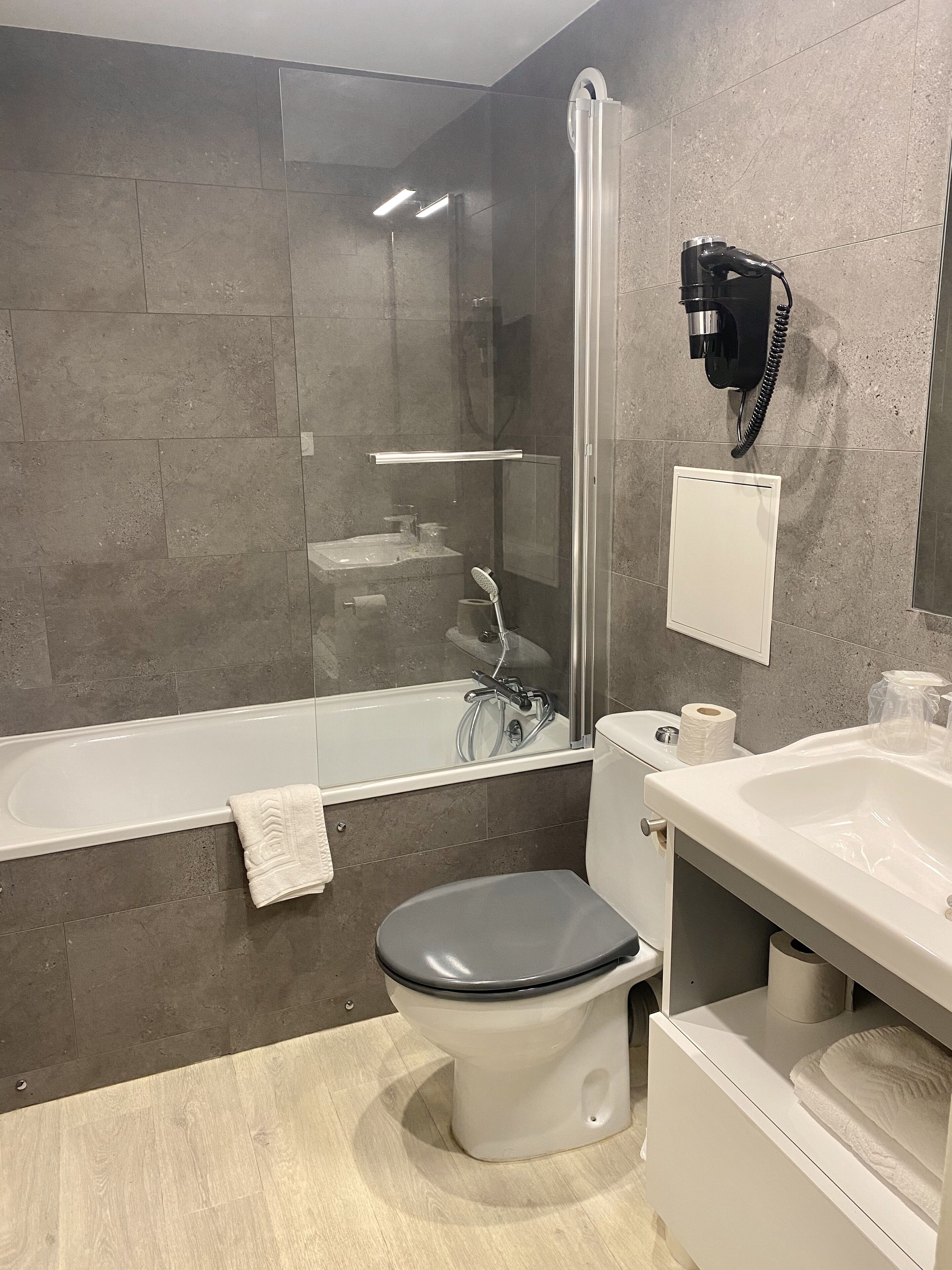 Ein modernes Badezimmer mit Duschkabine, Toilette, Badewanne und Waschbecken.