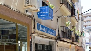 Un edificio con un cartello che indica 'Hostal Vitalamar' e un cartello con la scritta 'ciber'.