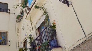 Un edificio con un cartello blu, ringhiera in metallo nero e piante in vaso.