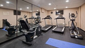 Uma academia com esteiras, elípticos e bicicleta ergométrica.
