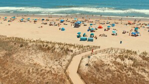 Una playa con numerosos sombrillas y gente.