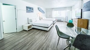Moderni hotellihuone, jossa on suuri sänky, työpöytä ja televisio.