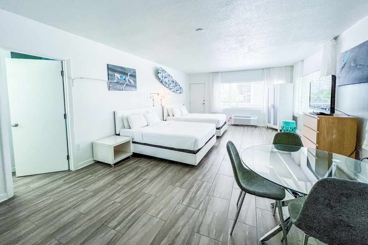 Une chambre d’hôtel moderne avec un grand lit, un bureau et une télévision.
