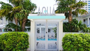 Portilla on kyltti, jossa lukee ”AQUA”, ja portin läpi näkyy uima-allas.