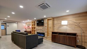 Un salon moderne doté d’un grand téléviseur à écran plat, d’une cheminée et d’un meuble de rangement en bois.
