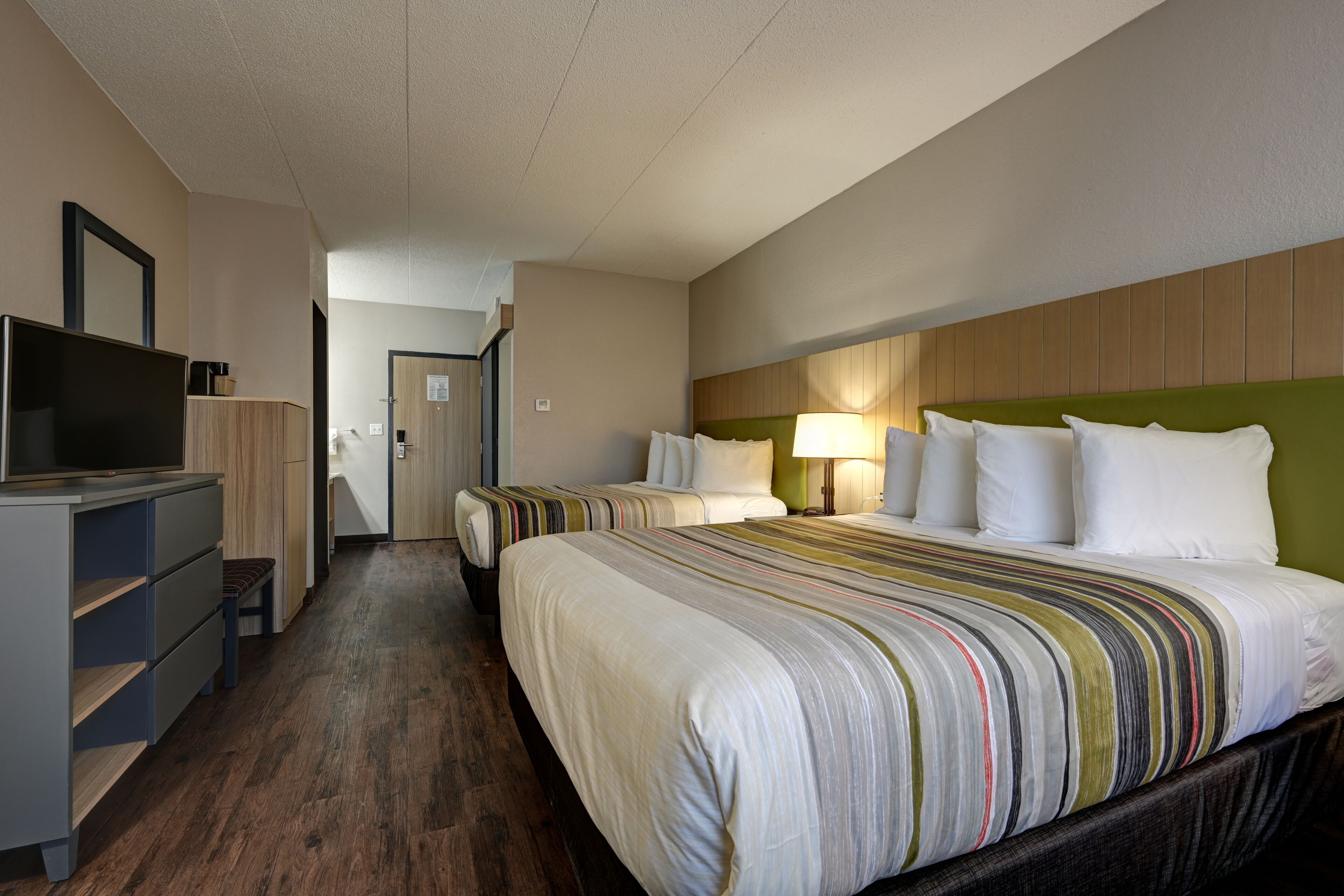 Une chambre d’hôtel avec un grand lit, une télévision, un bureau et une chaise.