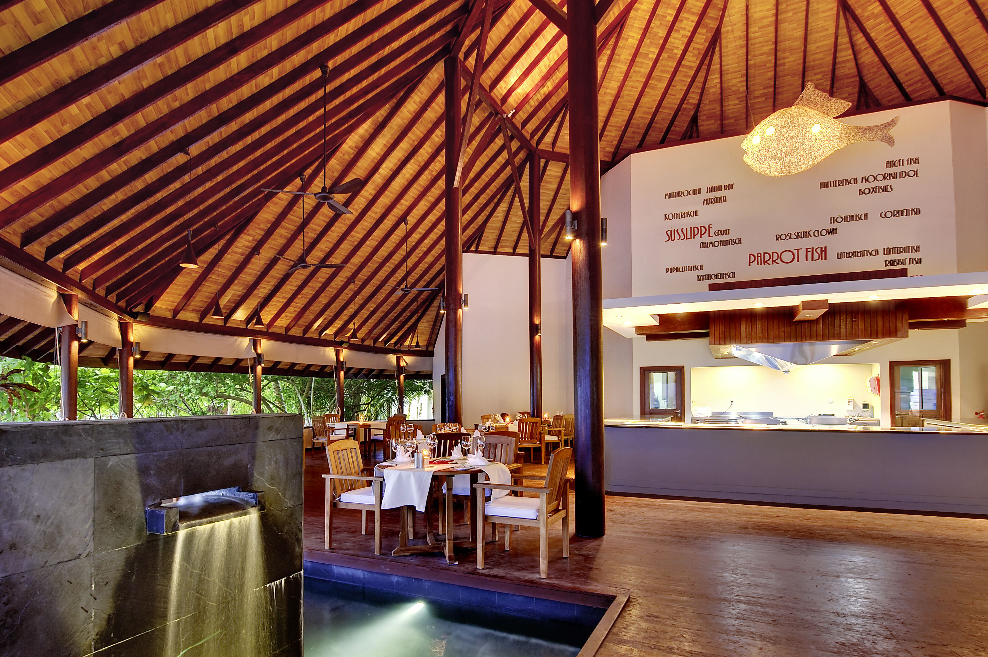 An indoor dining area with wooden beams, tables set for dining, and a menu on the wall.