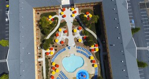 Una piscina al aire libre, sombrillas, sillones reclinables de piscina