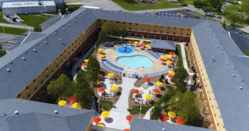 Una piscina al aire libre, sombrillas, sillones reclinables de piscina