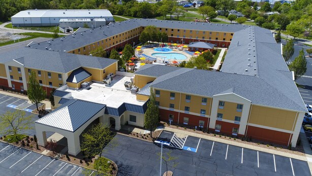Un hotel con un patio central que cuenta con una piscina y mobiliario para exteriores.