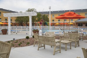 Una piscina al aire libre, sombrillas, sillones reclinables de piscina