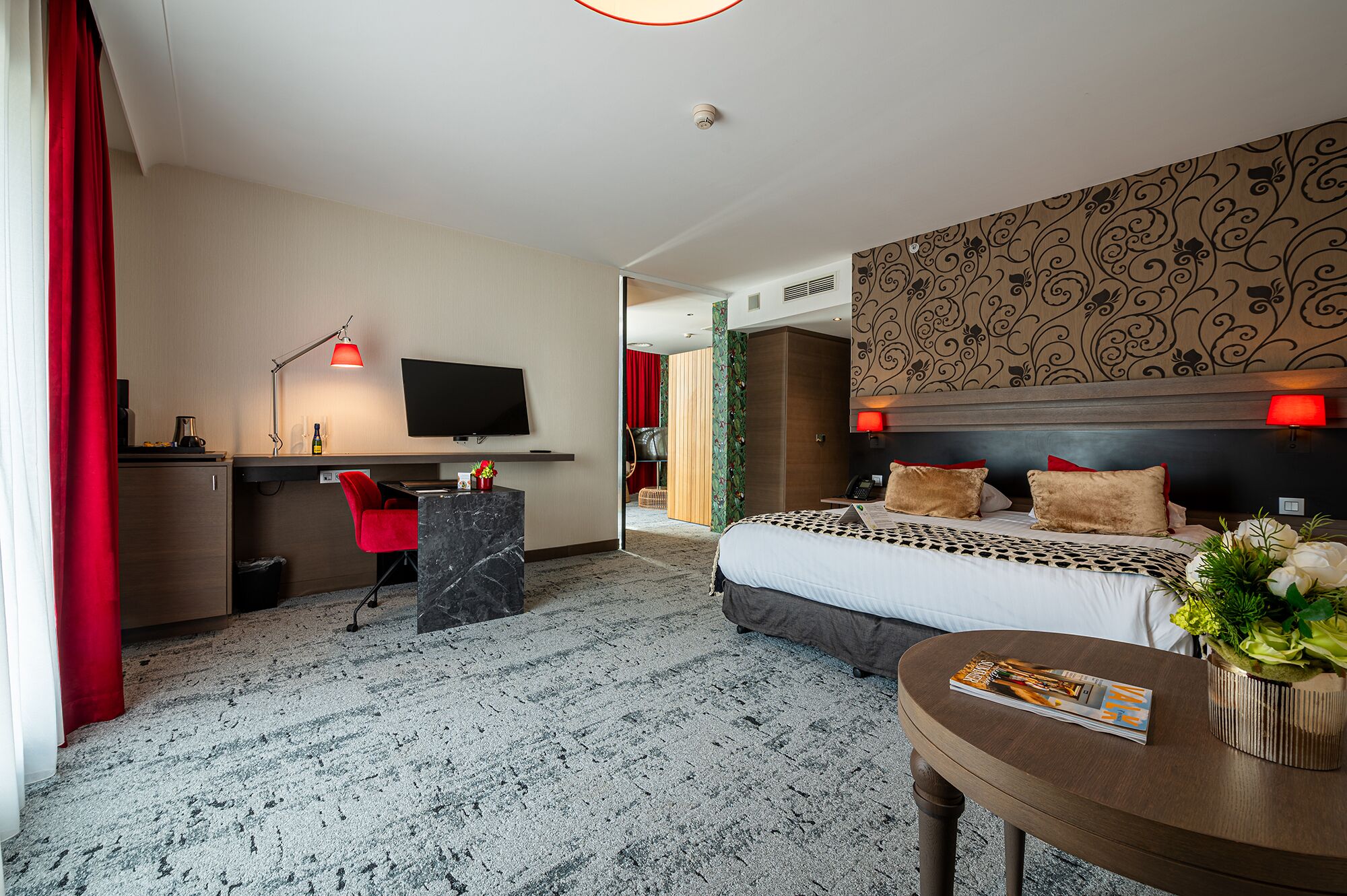 Ein Hotelzimmer mit Bett, Schreibtisch und Fernseher.
