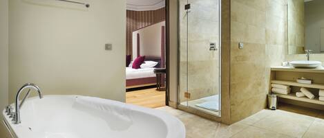 A modern bathroom with a freestanding bathtub, a glass-enclosed shower, and a vanity with a large mirror.