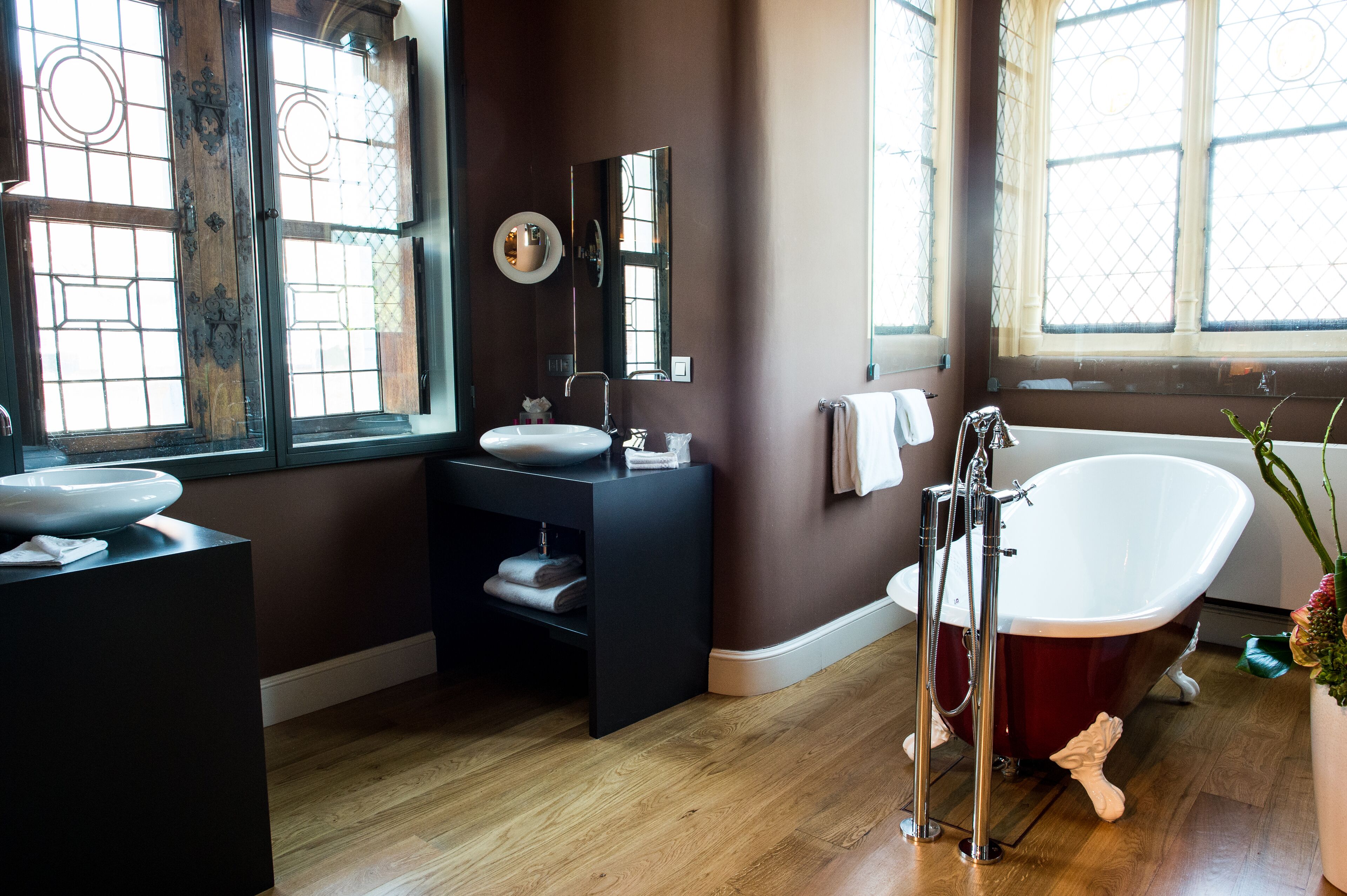 A bathroom with a freestanding bathtub, a vanity with a sink, and a large mirror.