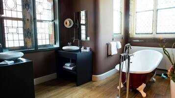 A bathroom with a freestanding bathtub, a vanity with a sink, and a large mirror.