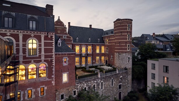 Een historisch gebouw met veel ramen, een binnentuin en een toren.