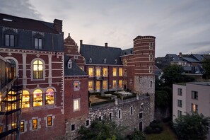 Un bâtiment historique doté de nombreuses fenêtres, d’une cour intérieure et d’une tour.