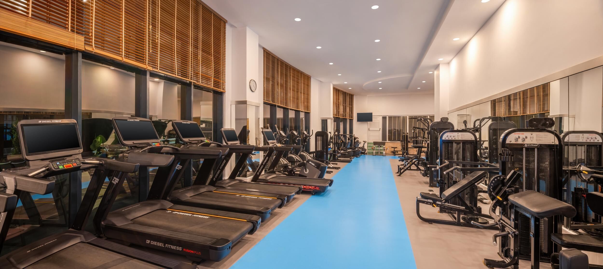 A gym with multiple treadmills, exercise bikes, and weight machines.