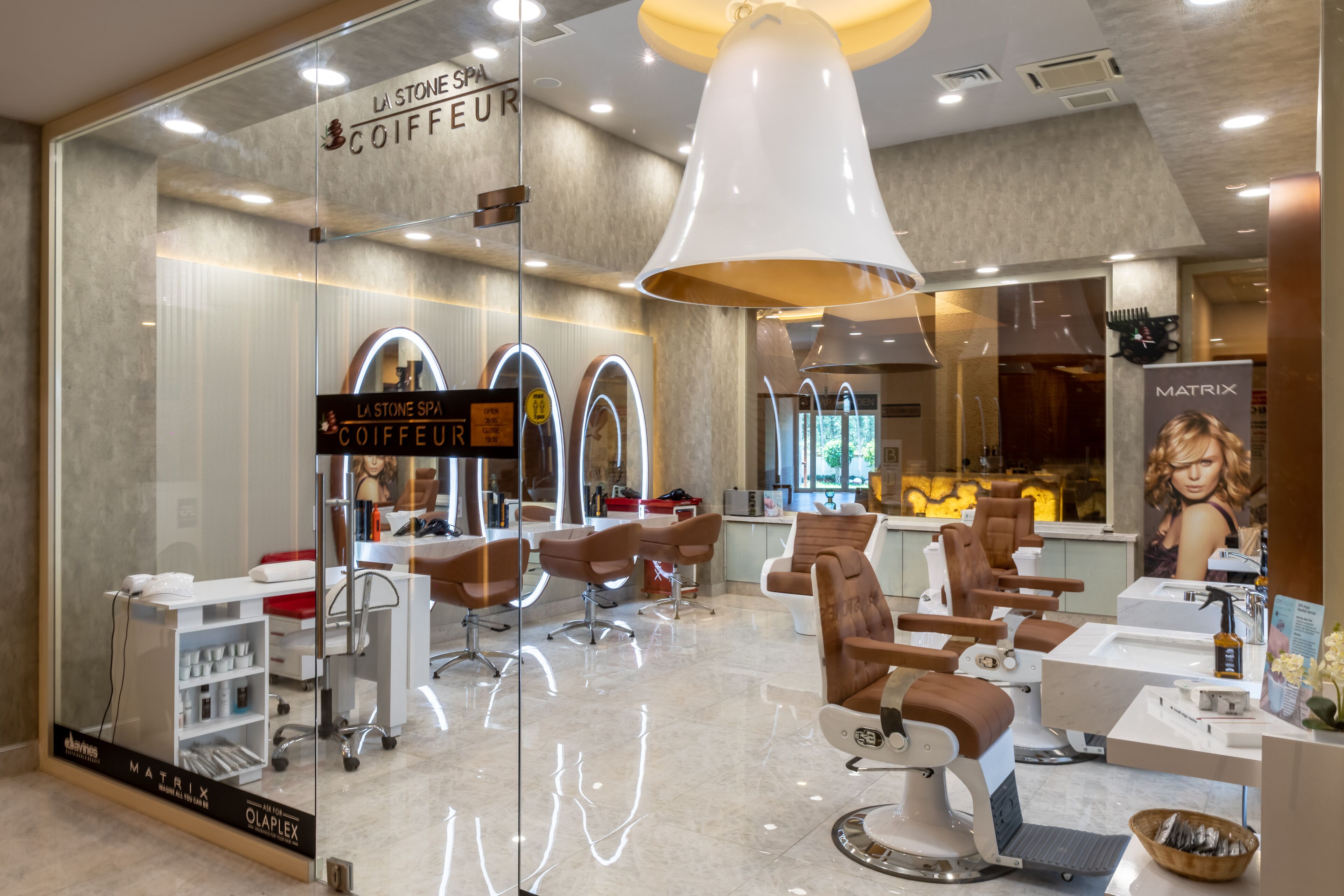 A modern salon interior with multiple hairdressing stations, a visible sign for 'La Stone Spa Coiffeur', and a large mirror reflecting the salon's interior.