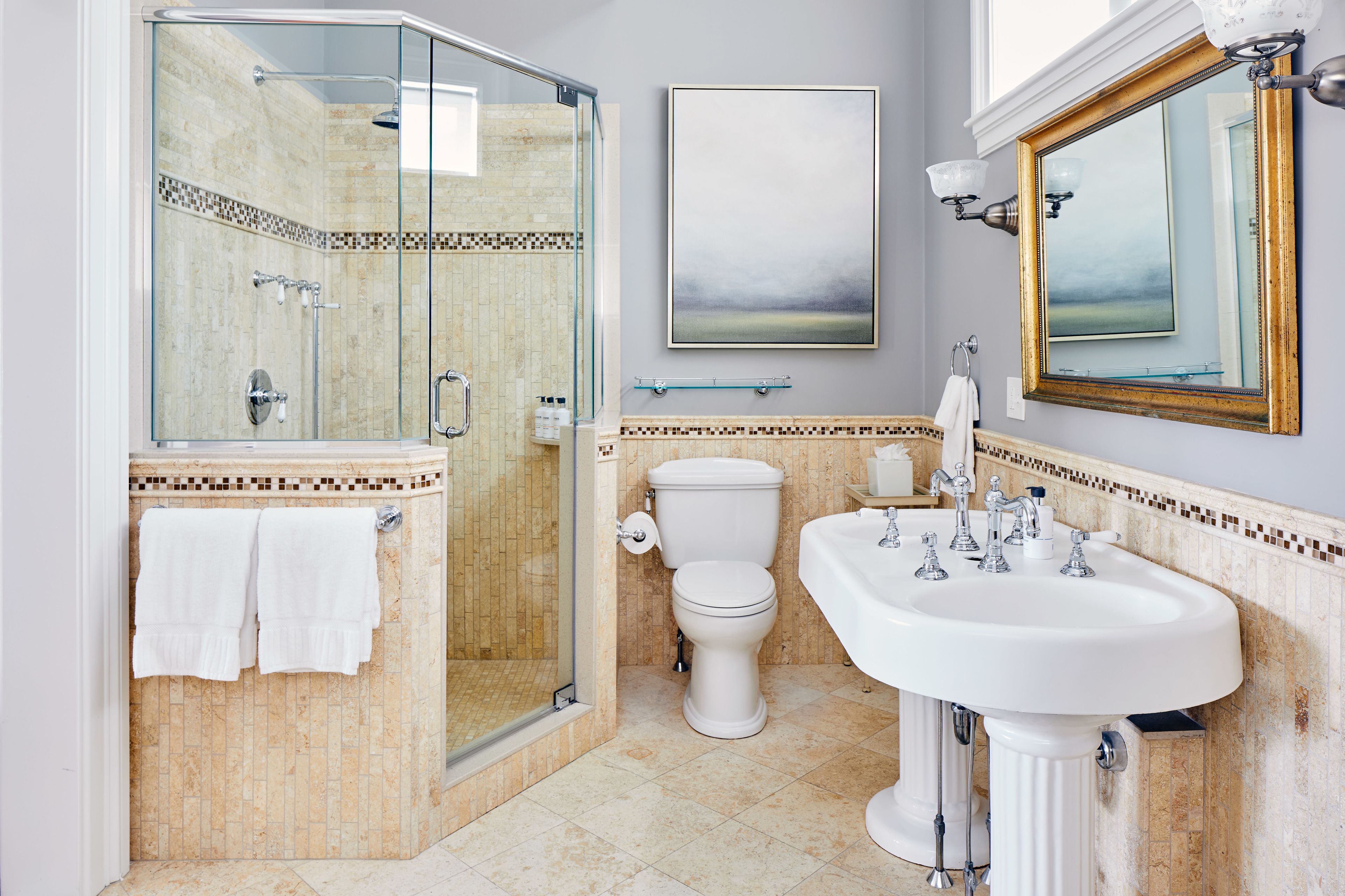 Une salle de bain avec une douche à parois de verre, des toilettes et un lavabo.