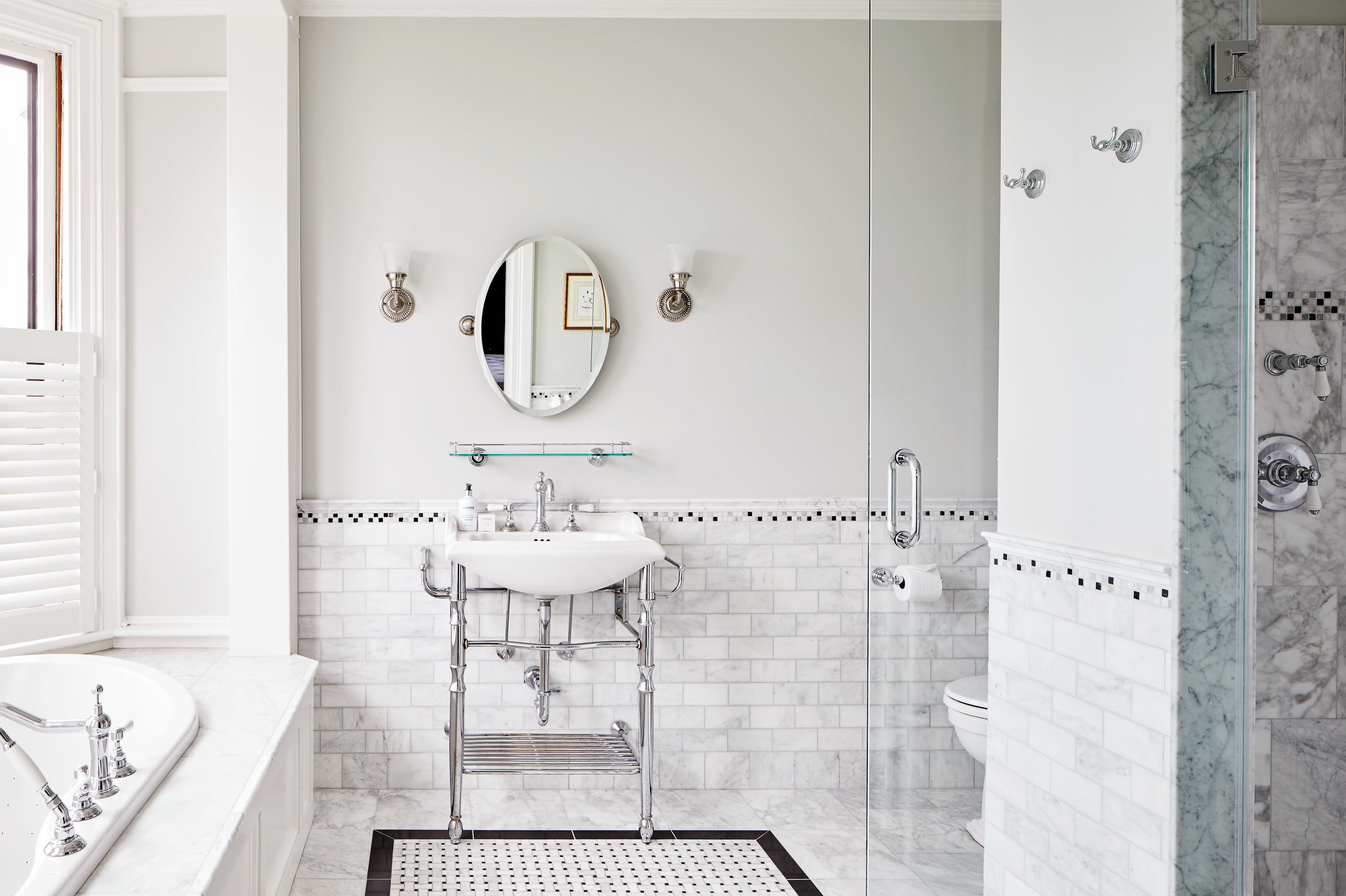 Ein modernes Badezimmer mit Waschbecken, Spiegel und Duschkabine aus Glas.