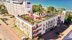 Un hotel con jardín en la azotea, aparcamiento y vistas al mar.