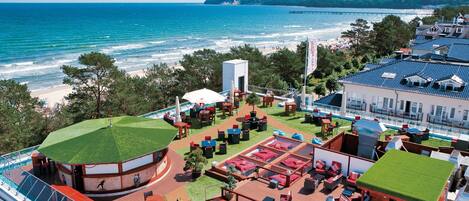 A rooftop deck with outdoor seating, a pool, and a view of the ocean.
