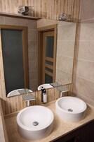 A bathroom with two sinks, a mirror, and a towel rack.