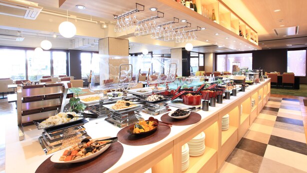 A buffet setup with various food items, utensils, and glassware. - Urban Hotel Kyoto (Kyoto)