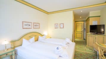 A hotel room with two beds, a television, a desk, and a chair.