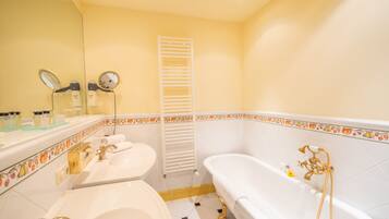 A bathroom with a bathtub, a sink, and a mirror.