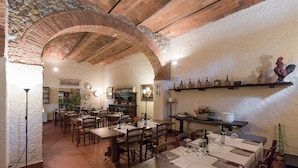 A restaurant with brick arches, wooden tables, and a rustic interior. - Relais Fattoria Valle (Greve in Chianti)