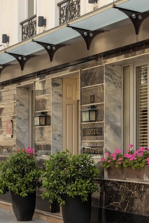 A hotel facade with a large entrance door, a number plaque, and a sign indicating the hotel name. - Hôtel Muguet (Paris)