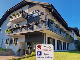 Un hotel con un cartel que indica que fue renovado recientemente y ofrece estacionamiento privado gratuito.