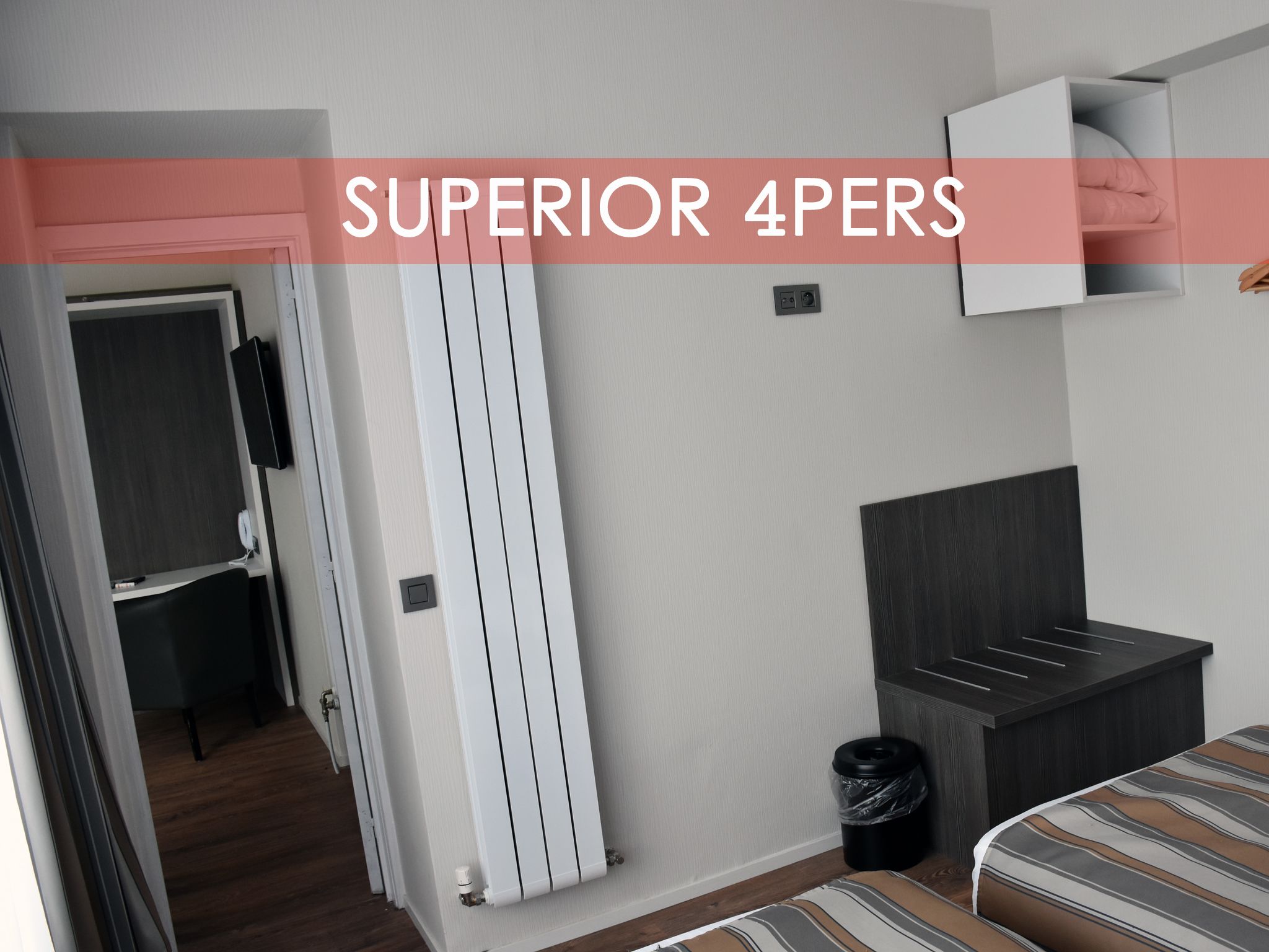 A room with a bed, a wardrobe, a radiator, and a trash bin.