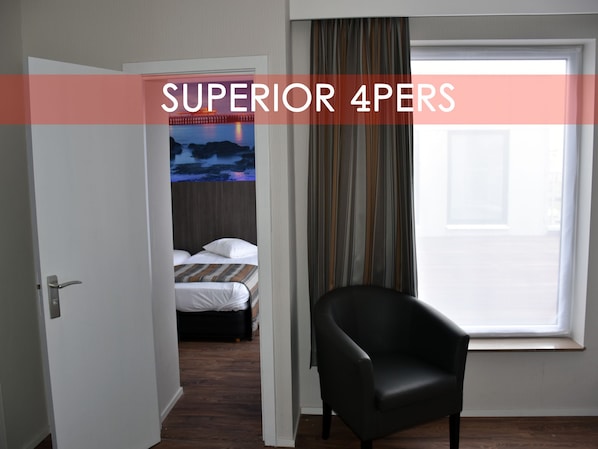 Una habitación de hotel con cama, una silla, una ventana con cortinas y una puerta.