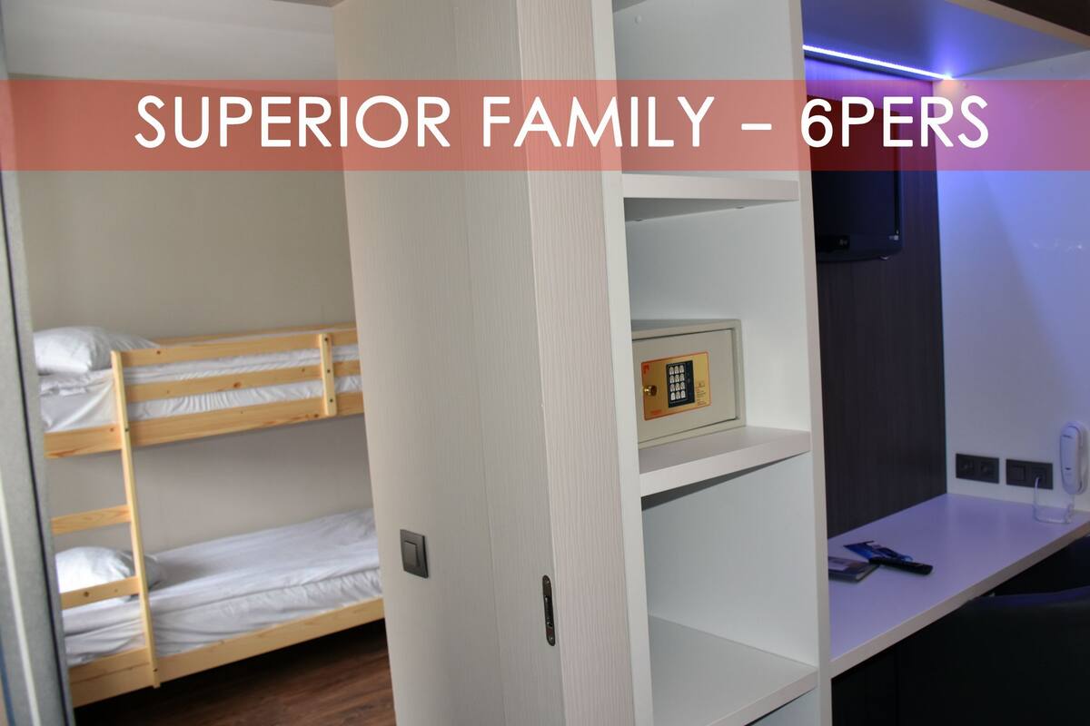 A bunk bed room with a desk and a safe.