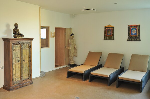 Una habitación con un aparador de madera, una estatua y tres sillones.