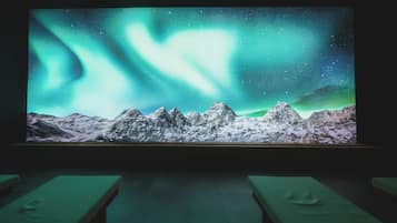 A projection of the Northern Lights over a mountainous landscape.
