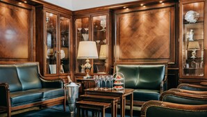 A luxurious room with wooden paneling, leather seating, and a glass display cabinet. - Gebhards Hotel (Goettingen)