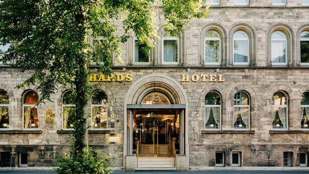 The exterior of the Haerdt's Hotel with a stone facade, arched windows, and a prominent entrance. - Gebhards Hotel (Goettingen)