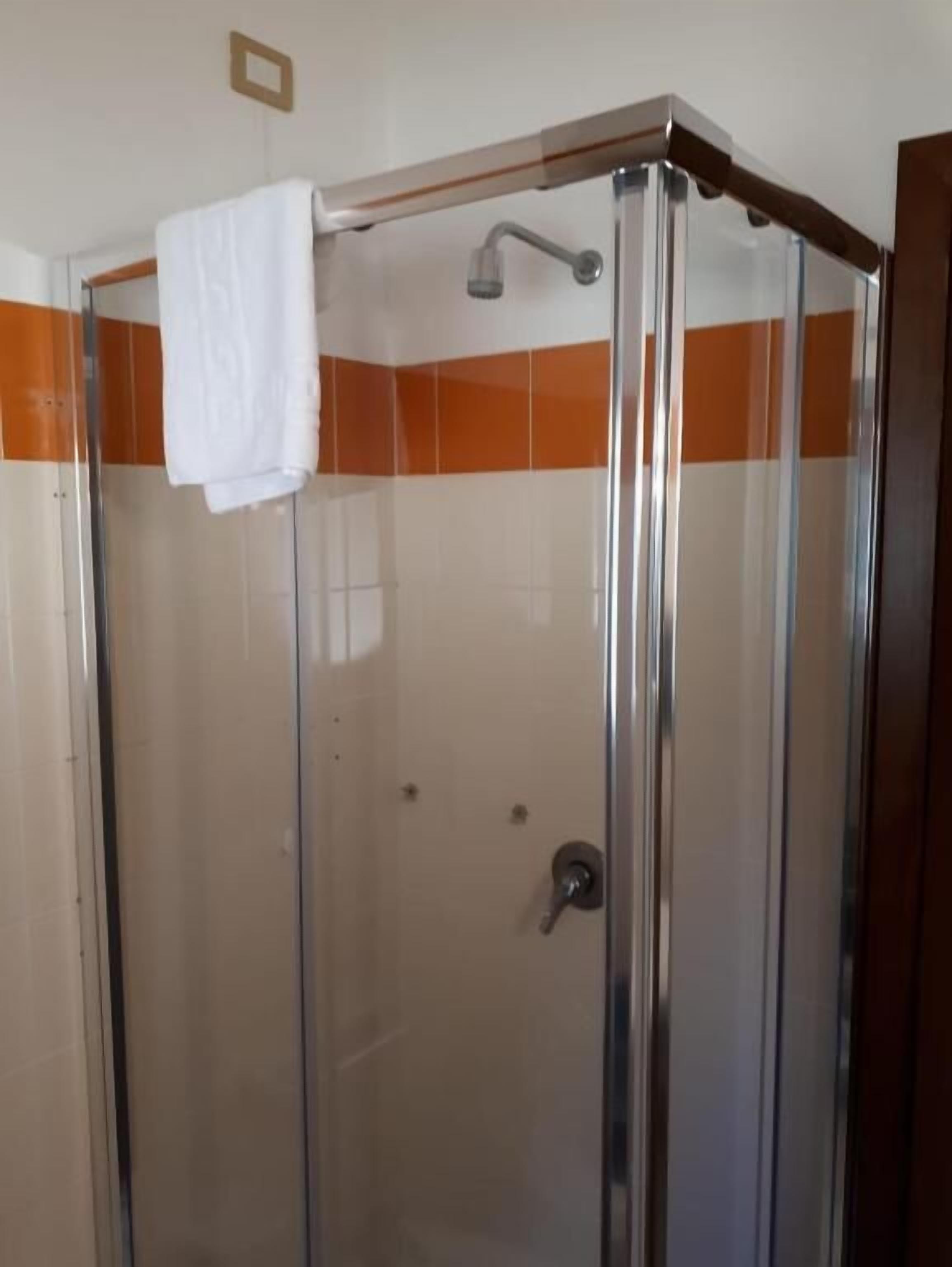 A glass-enclosed shower with a white towel hanging on the door handle.